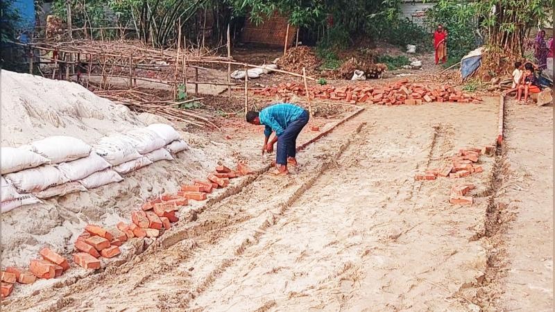 নবনির্মিত রাস্তার ইট তুলে নিলেন ইউপি সদস্য